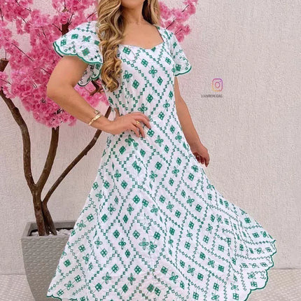Elegante vestido blanco con bordado verde.