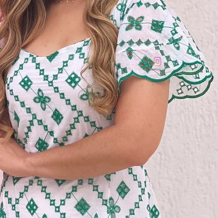 Elegante vestido blanco con bordado verde.