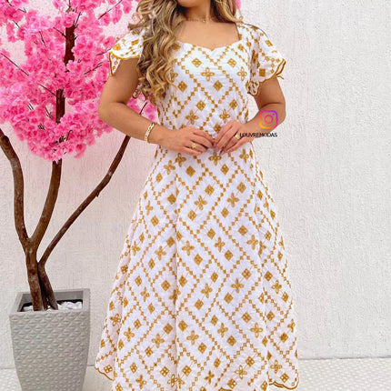 Vestido blanco con bordado dorado.