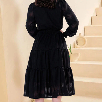 Vestido negro con tejido texturizado y detalles de encaje guipur en el cuello.