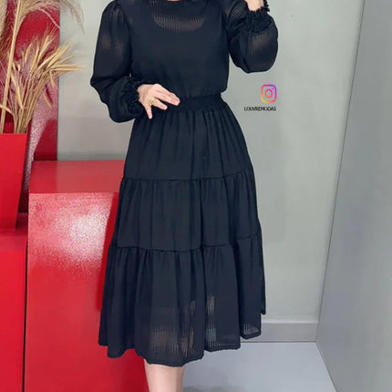 Vestido negro con tejido texturizado y detalles de encaje guipur en el cuello.