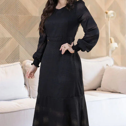 Vestido de gasa negro con manga larga y cintura elástica.