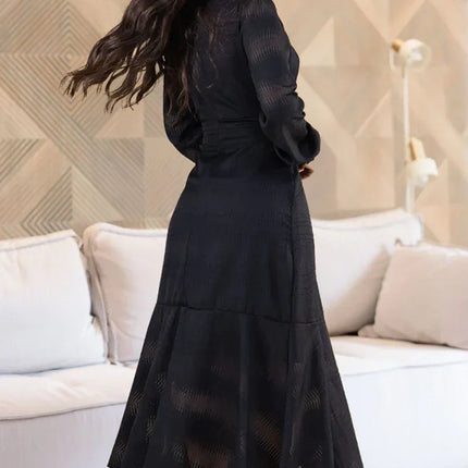 Vestido de gasa negro con manga larga y cintura elástica.